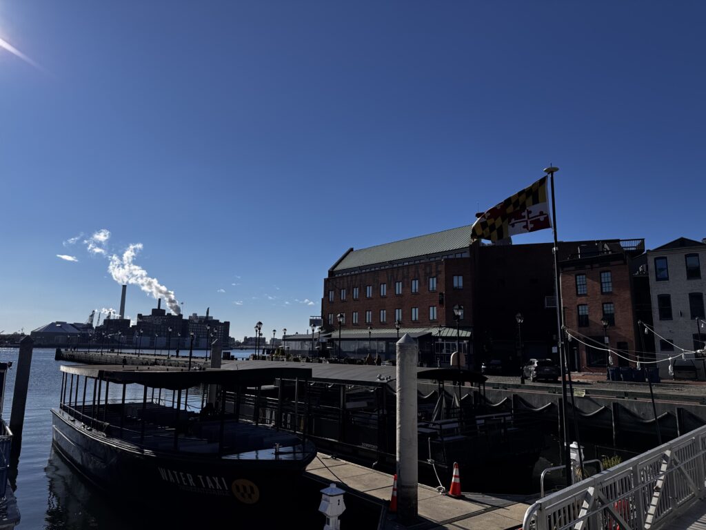 Harbor East skyline viewed from Thames Street in Fells Point, showing waterfront risk factors for storm surge, wind-driven rain, and disputed homeowners insurance claims.